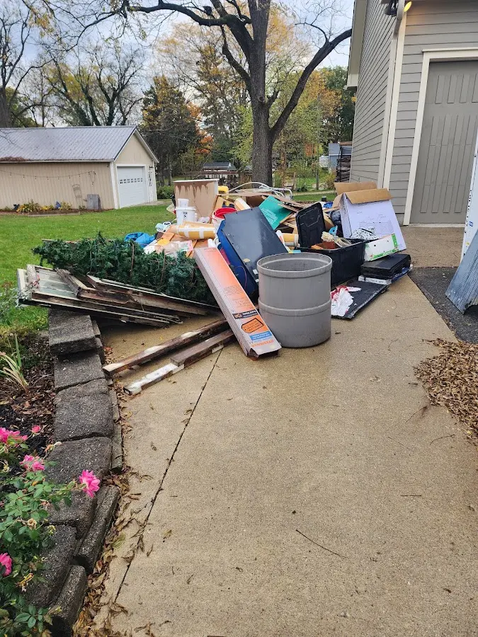 Dumpster being loaded with debris for 12 Yard Dumpster Rental in Denton